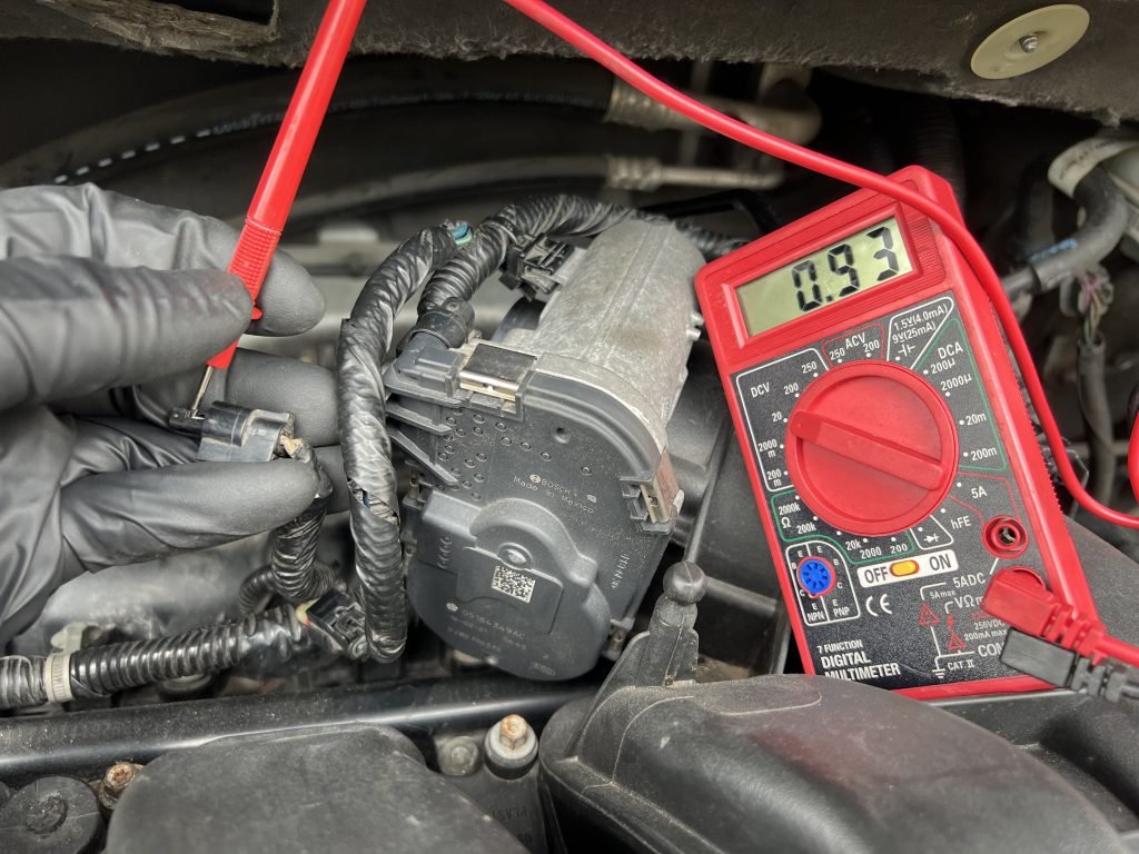 I Got Whipz Towing & Roadside Assistance Towing Mechanic using a multimeter to test voltage across a wire
