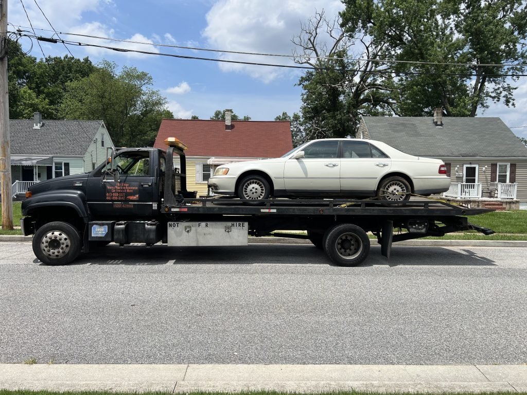 I got Whipz Towing & Roadside Assistance with a white infiniti q45 sedan towing near me from 39.327844, -76.704048 to 2412 Aisquith St, Baltimore, MD 21218