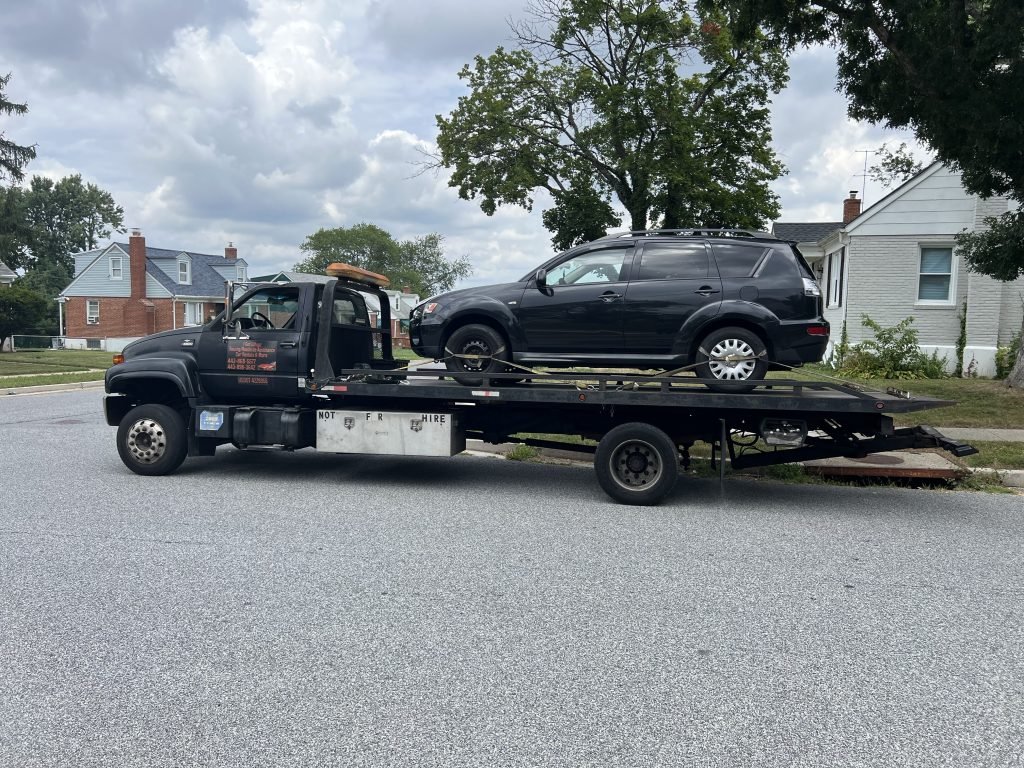 I Got Whipz Towing & Roadside Assistance with a black mitsubishi outlander suv towing near me from 7017 Brompton Rd Gwynn Oak,MD 21207 to 3300 W Cold Spring Ln, Baltimore, MD 21215